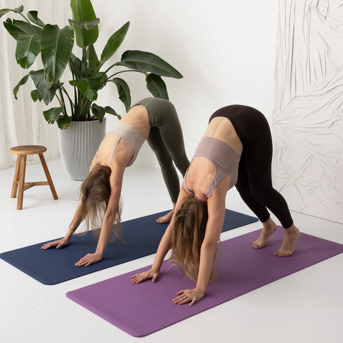 a couple of women standing on top of yoga mats