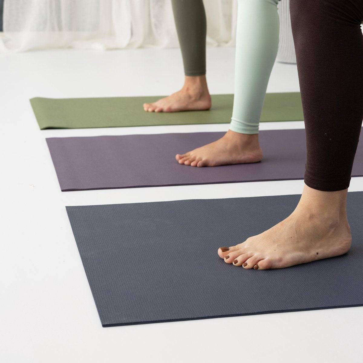 a person standing on a yoga mat with their feet on the mat