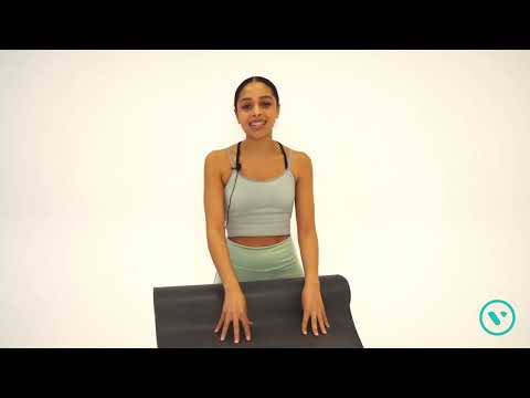 a woman is sitting on a yoga mat